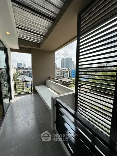 Modern balcony with city view, featuring sleek design and comfortable seating area.