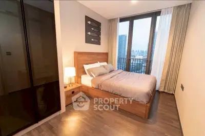 Modern bedroom with city view, featuring sleek wooden flooring and stylish decor.