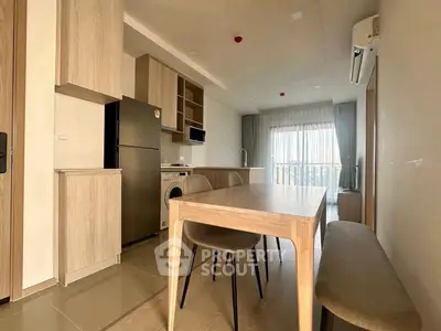 Modern kitchen and dining area with sleek wooden furniture and appliances in a bright apartment.