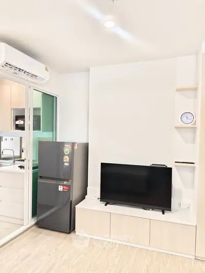 Modern living room with sleek TV setup and compact kitchen view