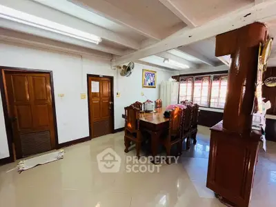 Charming dining area with wooden furniture and ample natural light in a cozy home setting.