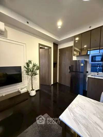 Modern living room with sleek kitchen and stylish decor in a contemporary apartment.