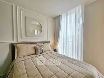 Elegant bedroom with modern decor and large window for natural light.