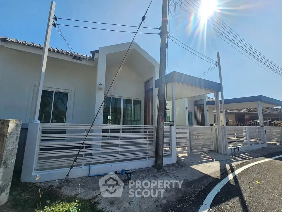 Modern single-story house with sleek design and spacious driveway under clear blue sky.