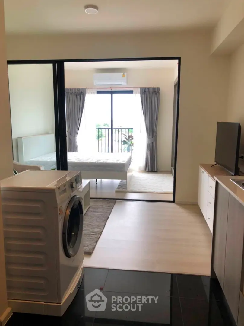 Modern apartment interior with washing machine and bedroom view