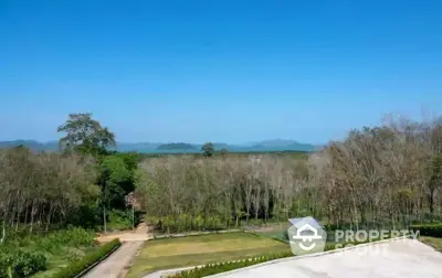 Stunning panoramic view of lush greenery and distant mountains from a serene property.