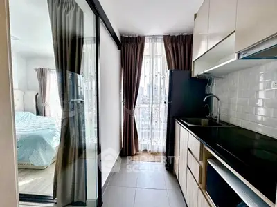 Modern kitchen with sleek cabinetry and adjacent bedroom view