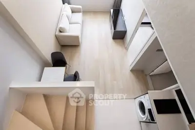 Modern loft apartment with sleek design, featuring a cozy living area and in-unit washing machine.