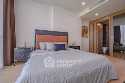 Modern bedroom with stylish decor and ensuite bathroom in luxury apartment.