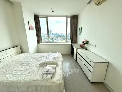 Bright bedroom with city view, modern furniture, and large window in high-rise apartment.