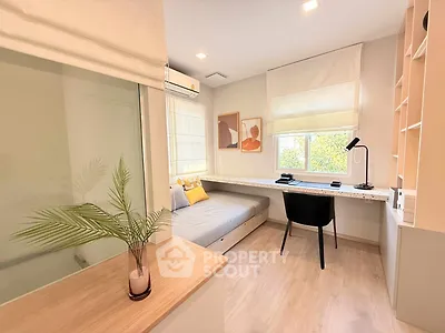 Modern study room with sleek desk, cozy daybed, and stylish decor in bright natural light.