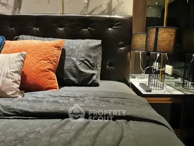 Luxurious bedroom with elegant decor and plush bedding, featuring stylish lamps and a sophisticated headboard.