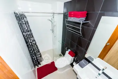 Modern bathroom with glass shower, sleek tiles, and stylish fixtures.