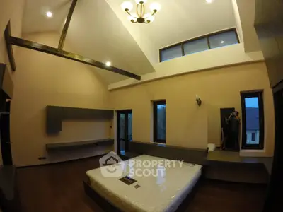 Spacious modern bedroom with high ceiling and large windows