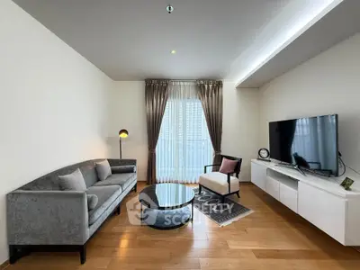 Modern living room with sleek furniture and large TV, featuring elegant curtains and wooden flooring.