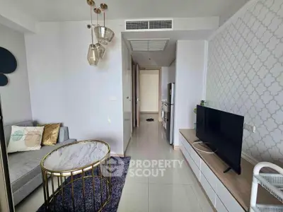 Modern living room with stylish decor and flat-screen TV, featuring elegant lighting and a cozy atmosphere.