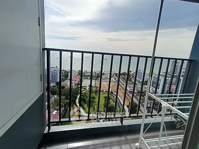 Stunning high-rise balcony view overlooking cityscape and ocean horizon, perfect for urban living.