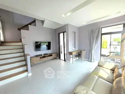 Spacious modern living room with sleek staircase and natural light