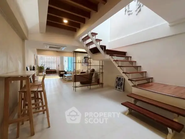 Spacious modern living room with stylish staircase and open layout, perfect for contemporary living.