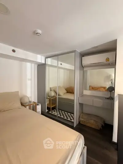 Cozy bedroom with mirrored wardrobe and air conditioning unit