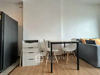 Modern apartment interior with sleek dining area and cozy living space, featuring minimalist furniture and wooden flooring.