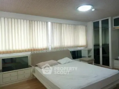 Spacious bedroom with large windows and modern furnishings