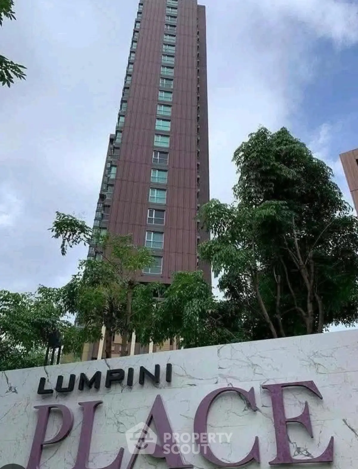 Modern high-rise building with lush greenery at Lumpini Place.