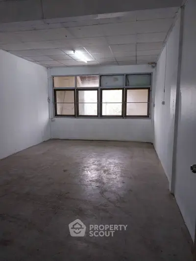 Spacious empty room with large windows and natural light