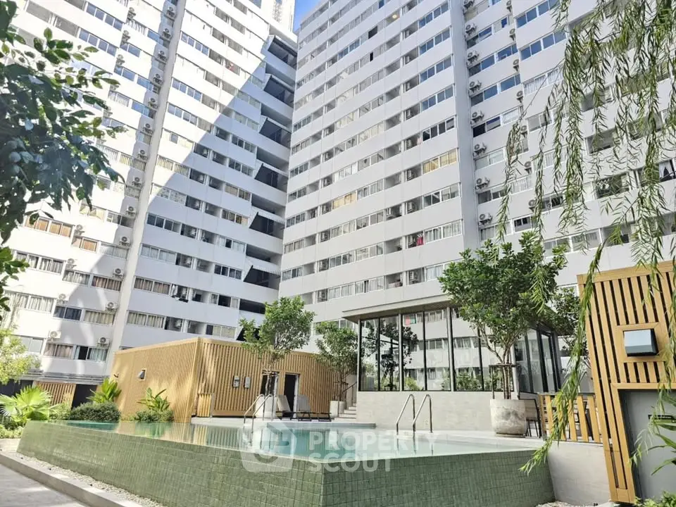 Modern apartment complex with pool and lush greenery