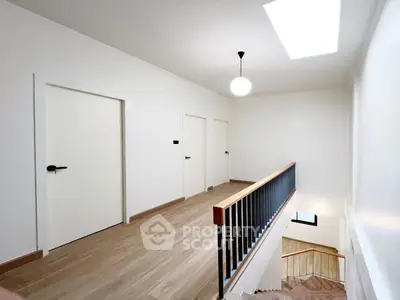 Spacious hallway with modern lighting and wooden flooring
