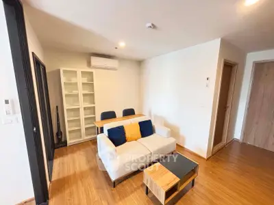 Modern living room with cozy sofa, wooden flooring, and stylish decor in a contemporary apartment.