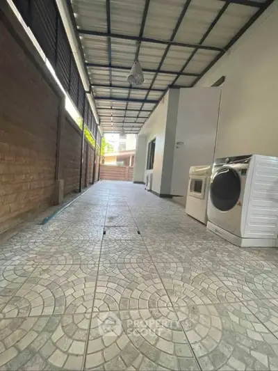 Spacious covered outdoor area with washing machine and dryer, perfect for laundry needs.