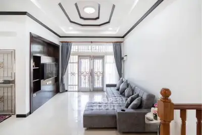 Spacious living room with modern gray sectional sofa and elegant ceiling design