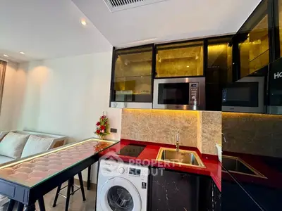 Modern kitchen with red countertop, built-in appliances, and washing machine in stylish apartment.