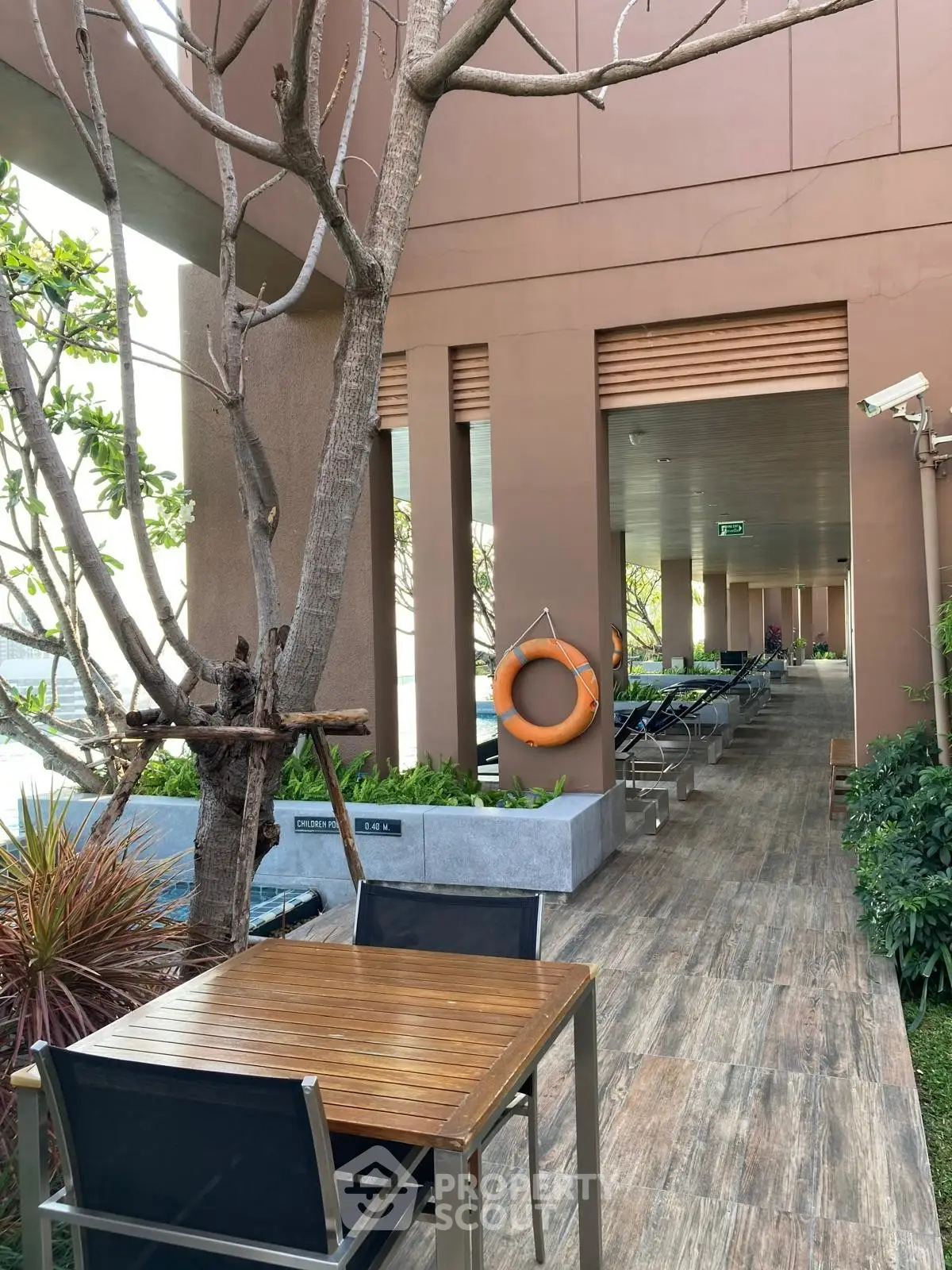 Luxurious outdoor poolside area with stylish seating and lush greenery in modern building.