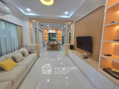 Modern living room with elegant decor and open layout, featuring a cozy sofa and stylish TV setup.