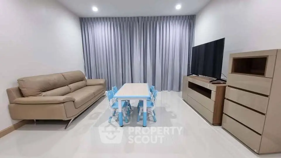 Modern living room with sleek furniture and large TV, perfect for family gatherings.
