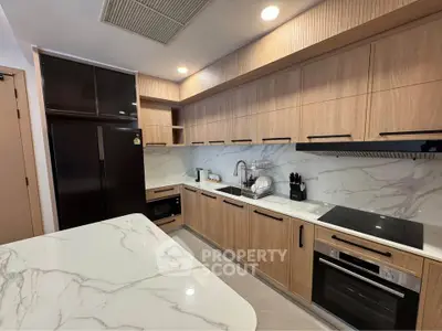 Modern kitchen with sleek cabinetry and marble countertops, featuring built-in appliances and ample storage space.