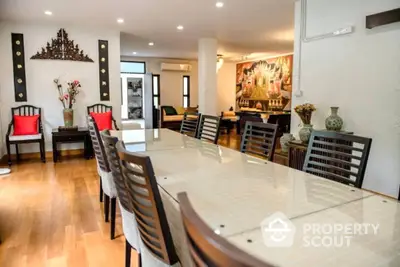 Spacious dining area seamlessly connects to an elegant living space, perfect for entertaining, with polished wooden floors and tasteful decor.