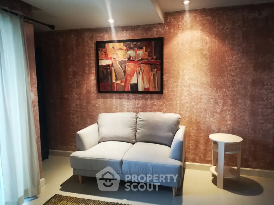 Cozy living room with stylish sofa and modern art on textured wall