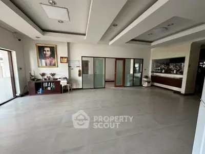 Spacious living room with modern ceiling design and large windows for natural light.