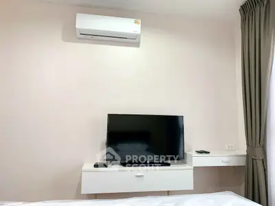 Modern bedroom with air conditioning and flat-screen TV, featuring sleek white furniture and elegant curtains.