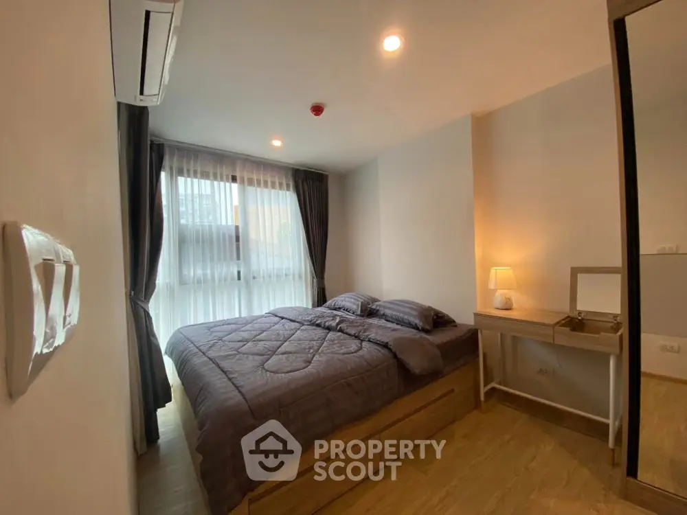 Cozy bedroom with modern decor, large window, and soft lighting for a relaxing ambiance.