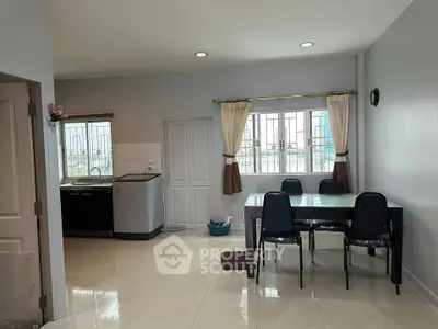 Spacious kitchen with dining area and modern appliances in a bright, airy setting.