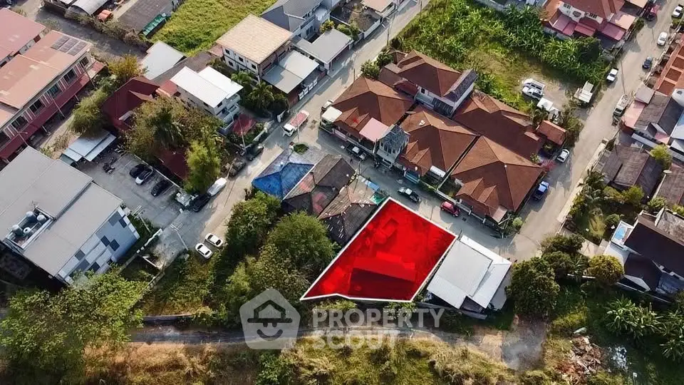 Aerial view of residential neighborhood with highlighted plot of land for sale.