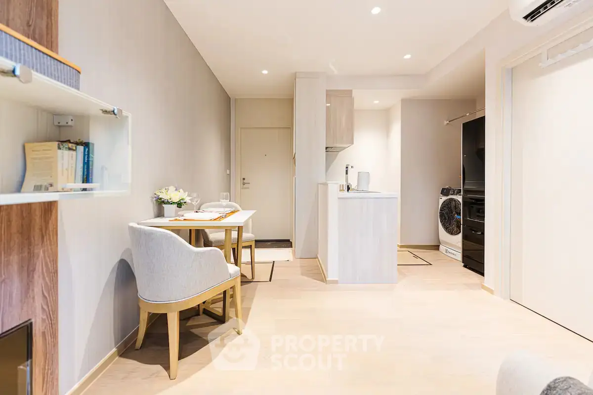Modern open-plan living area with kitchen and dining space, featuring sleek design and natural light.