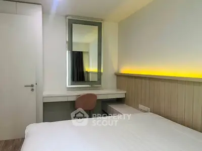 Modern bedroom with sleek design and ambient lighting, featuring a stylish vanity and comfortable chair.