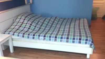 Cozy bedroom with modern design and colorful checkered bedding.