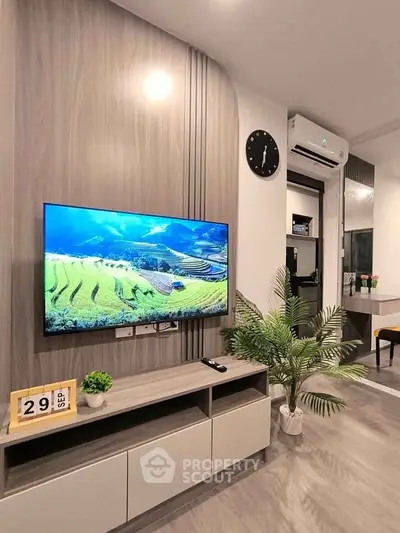 Modern living room with stylish TV setup and air conditioning, featuring sleek furniture and decor.