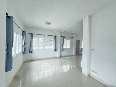 Spacious and bright living room with large windows and tiled flooring